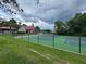 Community tennis court on a cloudy day, framed by lush greenery, and a community center at 199 Afton Sq # 108, Altamonte Springs, FL 32714