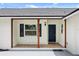 Inviting front entry with covered porch, decorative wood columns, and blue front door and shutter details at 2089 Sunderland Rd, Maitland, FL 32751