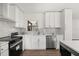 Bright kitchen with stainless steel appliances, stone backsplash, and white cabinetry at 2089 Sunderland Rd, Maitland, FL 32751