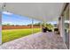Covered back patio with tiled flooring and seating area overlooking backyard and brick fence at 2181 Jessa Dr, Kissimmee, FL 34743