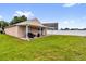 View of backyard with covered patio, well-maintained lawn, and privacy fence for outdoor enjoyment at 2181 Jessa Dr, Kissimmee, FL 34743