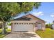 Tan single-Gathering home with a two-car garage and a well-manicured lawn at 2181 Jessa Dr, Kissimmee, FL 34743