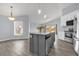 Well-designed kitchen with gray island, pendant lights, and stainless steel appliances at 2181 Jessa Dr, Kissimmee, FL 34743