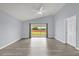 Living room featuring gray floors, slider to backyard, ceiling fan and light blue walls at 2181 Jessa Dr, Kissimmee, FL 34743