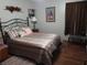 Comfortable bedroom featuring a wrought iron bed frame, wood floors, and warm decor at 2320 Ne 43Rd St, Ocala, FL 34479