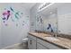 Charming bathroom features double sinks, granite countertops, and decorative mermaid themed wall art at 2560 Hayden Valley Street, Apopka, FL 32703