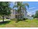Beautiful two-story home with a well-manicured lawn and mature landscaping with a palm tree at 2560 Hayden Valley Street, Apopka, FL 32703
