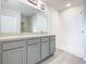 Bright bathroom featuring double vanity with gray cabinets and walk-in shower with white tiling at 313 Sofia Ln, Lake Alfred, FL 33850