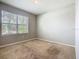 Bedroom with neutral walls, carpet, and a window overlooking the front yard at 313 Sofia Ln, Lake Alfred, FL 33850