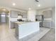 Spacious kitchen with gray cabinets, stainless steel appliances, and center island with tile floors at 313 Sofia Ln, Lake Alfred, FL 33850