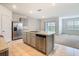 Open kitchen layout with stainless steel appliances, island, and lots of counter space to living area at 313 Sofia Ln, Lake Alfred, FL 33850