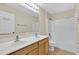 Bright bathroom with double sinks, wood cabinets, tile floors, and a shower-tub combo at 3322 Park Branch Ave, Clermont, FL 34711