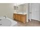 Bathroom featuring double sinks, tiled floors, and a soaking tub at 3322 Park Branch Ave, Clermont, FL 34711