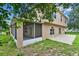 Exterior rear view of home featuring a screened-in patio, concrete patio, and lush green lawn at 3322 Park Branch Ave, Clermont, FL 34711