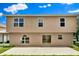 Back exterior view of home featuring a large patio with sliding glass door and multiple windows at 3322 Park Branch Ave, Clermont, FL 34711