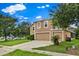Two story home featuring an attached two car garage, driveway, lawn, and mature trees at 3322 Park Branch Ave, Clermont, FL 34711