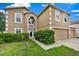 Exterior front of home featuring mature shrubbery, well-manicured lawn, and an attached garage at 3322 Park Branch Ave, Clermont, FL 34711