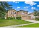 Exterior front of home featuring manicured lawn, mature trees, driveway, and two-car garage at 3322 Park Branch Ave, Clermont, FL 34711