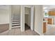 Hallway view of staircase, closet, and kitchen featuring wood cabinets and tile flooring at 3322 Park Branch Ave, Clermont, FL 34711