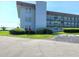 A view of the condo building's exterior shows landscaping, covered walkways, and easy access parking at 333 Lake Howard Nw Dr # 201A, Winter Haven, FL 33880