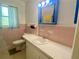 Vintage bathroom features pink tiling, a vanity with storage, and a mirror with lighting at 3695 Dale Ct, Mount Dora, FL 32757