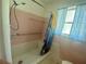 Modest bathroom featuring a walk-in shower with pink tiling, accessible grab bar, and blue shower curtain at 3695 Dale Ct, Mount Dora, FL 32757