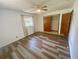 Well-lit bedroom with two windows and plank flooring and a closet with traditional doors at 3695 Dale Ct, Mount Dora, FL 32757