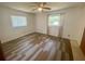 Bright bedroom with plank flooring, a ceiling fan and two windows offering a pleasant view at 3695 Dale Ct, Mount Dora, FL 32757