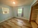 Bedroom with plank flooring, closet, an AC window unit and two windows for natural light at 3695 Dale Ct, Mount Dora, FL 32757