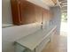 Garage featuring overhead storage cabinets and a workbench; a door open to the outside at 3695 Dale Ct, Mount Dora, FL 32757