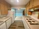 Galley kitchen with adjacent living space and updated vinyl flooring is ready for updates at 3695 Dale Ct, Mount Dora, FL 32757