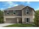 Charming two-story home with gray siding, shutters, a well-manicured lawn, and an attached garage at 3820 Elk Bluff Rd, St Cloud, FL 34772
