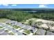 An aerial view of new homes in a neighborhood with lush green trees and a lake in the distance at 3964 Mayhill Loop, Eustis, FL 32736