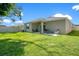 Grassy backyard with a covered patio area and chairs for relaxation at 3964 Mayhill Loop, Eustis, FL 32736
