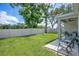 Landscaped backyard featuring a white vinyl fence, lush green grass, and a covered patio area at 3964 Mayhill Loop, Eustis, FL 32736