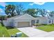 Aerial view of the single-story home with a well-manicured lawn and a long driveway leading to the two car garage at 3964 Mayhill Loop, Eustis, FL 32736