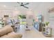 Bright living room features a comfortable sofa, TV, ceiling fan, and backyard access at 3964 Mayhill Loop, Eustis, FL 32736