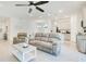 Open-concept living room with tile flooring, a ceiling fan, and light gray kitchen cabinets at 3964 Mayhill Loop, Eustis, FL 32736