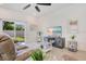 Well-lit living room features a comfortable sofa, TV, ceiling fan, and backyard access at 3964 Mayhill Loop, Eustis, FL 32736