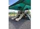 Community playground with multiple slides, climbing features, and a swing set under a shaded canopy at 406 Cool Summer Ln, Davenport, FL 33837