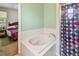 A tiled bathroom with a soaking tub and a glass-doored shower at 419 Cierra Oaks Cir, Lady Lake, FL 32159