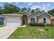 Lovely single-story home with attached garage, manicured front yard, and welcoming facade at 419 Cierra Oaks Cir, Lady Lake, FL 32159