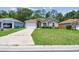 Charming single-story home features a well-maintained lawn, attached garage, and inviting curb appeal at 419 Cierra Oaks Cir, Lady Lake, FL 32159