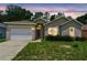 Charming single-story home with a well-manicured lawn and attached garage under a beautiful evening sky at 419 Cierra Oaks Cir, Lady Lake, FL 32159