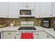 White electric range and oven, and decorative mosaic tile backsplash at 419 Cierra Oaks Cir, Lady Lake, FL 32159