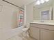A full bathroom with tile surround tub and shower and neutral vanity at 463 Cape Honeysuckle Pl, Sanford, FL 32771