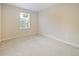 Empty bedroom with a large window that provides natural light and neutral carpeting at 463 Cape Honeysuckle Pl, Sanford, FL 32771
