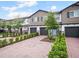 Street view of charming townhomes with brick driveways, garages and manicured landscaping at 463 Cape Honeysuckle Pl, Sanford, FL 32771