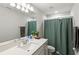 Bright bathroom featuring a quartz countertop, framed mirror, and a shower-tub combo with neutral-colored tile at 5065 Sparkling Water Way, Kissimmee, FL 34746