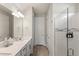 Well-lit bathroom with modern vanity, quartz countertops, and a glass-enclosed shower at 5065 Sparkling Water Way, Kissimmee, FL 34746